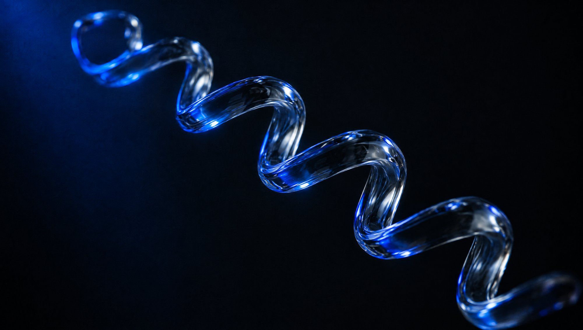 A long spiral helix of clear glass floating diagonally in darkness, catching blue light along its curves.